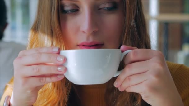 Retrato de cerca de la joven bonita y feliz, Chica sentada en un café, Beber café de la mañana en la ciudad . — Vídeo de stock