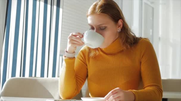 Portrait Gros plan de Jolie jolie jeune femme, fille assise dans un coffre-fort travaillant sur un téléphone mobile, écrit des messages texte, boire le café du matin en ville . — Video