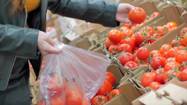 Csinos fiatal szép vörös haj nő vásárol élelmiszer, gyümölcs, paradicsom a piacon, a szupermarketben. Lány úgy dönt, termékek, zöldségek, gyümölcsök a boltban.Vásárlás, Vegán értékesítési koncepció. — Stock videók