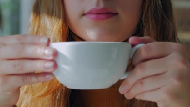 Porträtt Närbild av glad söt ung kvinna, Flicka sitter i ett café, dricka morgonkaffe i staden. — Stockvideo