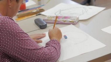 Sanatçı, tuval kağıdına sarı boya çizgisi çizer, stüdyodaki sanatçı, yaratıcı, tuvalin üzerinde fırça hareketi yapar. Bir sanat eseri kavramı.