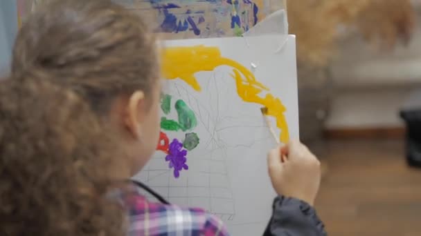 絞り加工: アーティスト アート スタジオ、手をキャンバスに筆塗りを持つ少女。スタジオとキャンバス上に描画でイーゼルに座って、ブラシのペンキを得るアーティストの子供手 — ストック動画