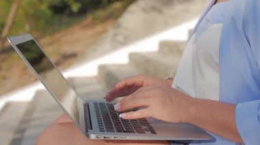 İş Lady Laptop Üzerinde Çalışan, Bir Laptop ile Mavi Takım Elbise çekici Esmer, çekici kadın açık havada onu bilgisayar üzerinde çalışan.