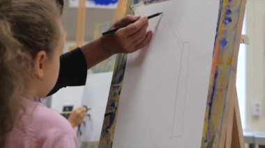 Sanatçının Genç Elleri, Küçük Kız Sanatçı Fırça ile Bir Tablo Boyar, Tablo Oturur ve Tablo Çizer. Çizim Süreci: Sanatçılar Stüdyosunda El Kızı Tabloda Çiziyor.