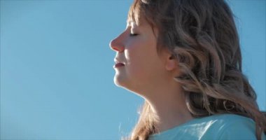 Portrait of a European woman or girl raising her face to the sun. A woman receives vitamin D from the sun