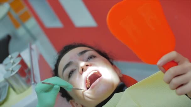 Mujer dentista tratando dientes a mujer paciente en clínica. Doctora Profesional Estomatóloga en el Trabajo. Concepto Dental Check Up. — Vídeo de stock