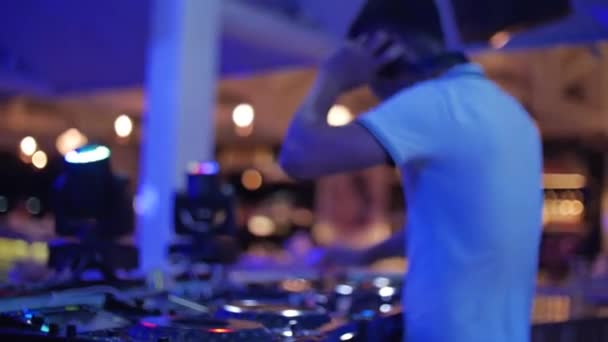Silhouette On Blurred Background ein DJ-und DJ-Soundkontrollpult, um Tanzmusik mit hellen Farbblitzen zu mischen zeigen eine Disco club.Play elektronische Musik auf einem Mischpult, Farblicht in einem Nachtclub — Stockvideo
