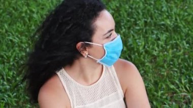 Parkta koruyucu maske takan ve ovid-19 maskesi takan genç bir kadının portresi. Sağlık ve güvenlik konsepti, N1H1 koronavirüs, virüs koruması, salgın hastalık.