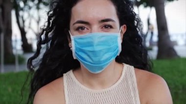 Sokakta koruyucu maske takan ve ovid-19 maskesi takan genç bir kadının portresi. Sağlık ve güvenlik konsepti, N1H1 koronavirüs, virüs koruması, salgın hastalık.