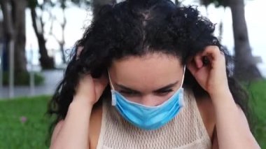 Sokakta koruyucu maske takan ve ovid-19 maskesi takan genç bir kadının portresi. Sağlık ve güvenlik konsepti, N1H1 koronavirüs, virüs koruması, salgın hastalık.