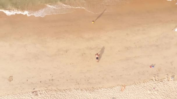 Légi kilátás a strandra felülről, kevés ember, egy férfi fekvőtámaszozik a homokban, a strand karantén után, a Kovid-19-es járvány után, ázsiai strandok. Koncepció Sport — Stock videók