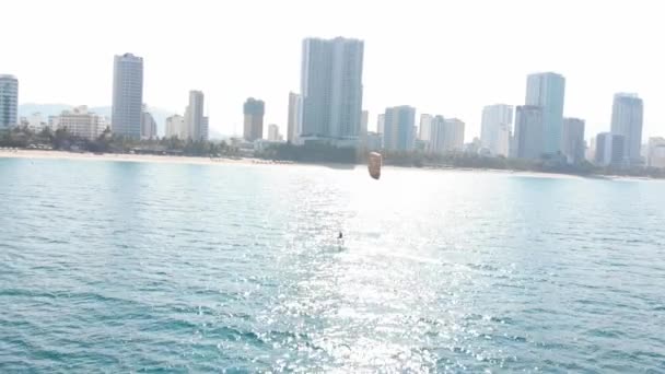 Letecký pohled na městskou pláž a aktivní lidi praktikující kite surfing a windsurfing. Kitesurfing místo, sportovní koncept, zdravý životní styl, lidský let. — Stock video