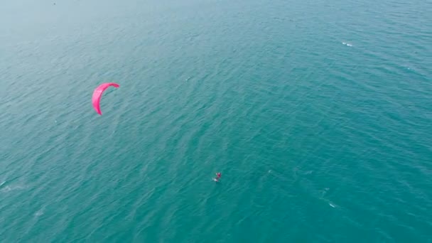 Légi kilátás a város strandjáról és aktív emberek gyakorló sárkány szörfözés és szörfözés. Kitesurfing hely, sport koncepció, egészséges életmód, emberi repülés. — Stock videók