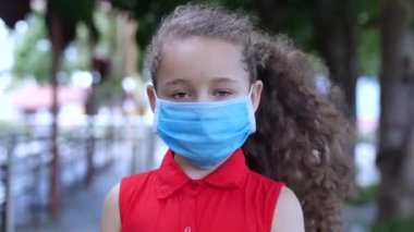 Covid-N1H1 salgınından kalma koruyucu maskelerle sokakta duran sevimli küçük kız. Yaşam Sağlığı ve Güvenliği kavramı, Covid-19, Virüs Koruması, Sözde bir Salgın. Coronavirus N1H1.