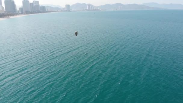 Luchtfoto van het stadsstrand en actieve mensen die kitesurfen en windsurfen beoefenen. Kitesurfen plaats, sport concept, gezonde levensstijl, menselijke vlucht. — Stockvideo