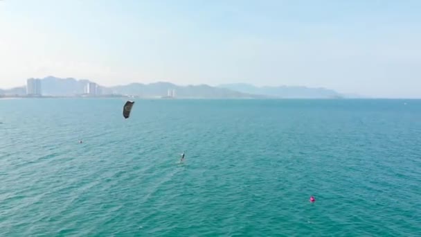 Vista aérea de la playa de la ciudad y gente activa practicando kitesurf y windsurf. Kitesurf lugar, concepto deportivo, estilo de vida saludable, vuelo humano. — Vídeos de Stock