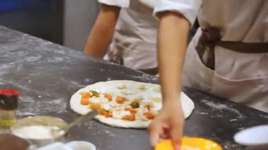 Pizza fırında. Fırında bir ateş yanıyor. Pizza kabuğunu kullanarak pizzayı fırından çıkararak hazır olup olmadığını kontrol eder..