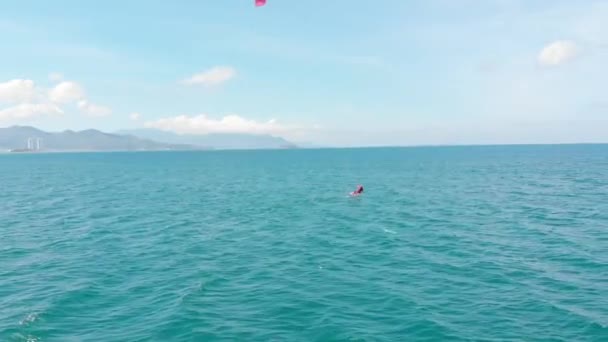 Vue aérienne de la plage de la ville et des personnes actives pratiquant le kite surf et la planche à voile. Lieu de kitesurf, concept sportif, mode de vie sain, vol humain. — Video