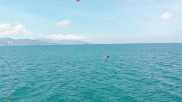 Vista aérea de la playa de la ciudad y gente activa practicando kitesurf y windsurf. Kitesurf lugar, concepto deportivo, estilo de vida saludable, vuelo humano. — Vídeo de stock