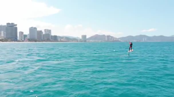 Luogo di kitesurf, concetto di sport, stile di vita sano, volo umano. Vista aerea della spiaggia della città e delle persone attive che praticano kite surf e windsurf. — Video Stock