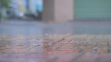 Büyük yaz ya da sonbahar yağmurları şehrin asfaltına düşer ve büyük bir su birikintisine dönüşerek caddeyi sular altında bırakır. Şiddetli yağmurda arabaları ve motosikletleri geçmek.