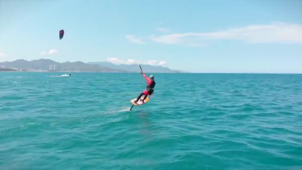 Lieu de kitesurf, concept sportif, mode de vie sain, vol humain. Vue aérienne de la plage de la ville et des personnes actives pratiquant le kite surf et la planche à voile. — Video