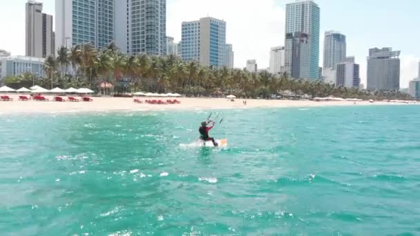 Kitesurfen plaats, sport concept, gezonde levensstijl, menselijke vlucht. Luchtfoto van het stadsstrand en actieve mensen die kitesurfen en windsurfen beoefenen. — Stockvideo