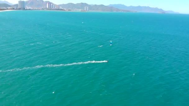 Kitesurfing place, sports concept, healthy lifestyle, human flight. Aerial view of the city beach and active people practicing kite surfing and windsurfing. — Stock Video