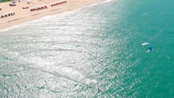 Kitesurfing place, sports concept, healthy lifestyle, human flight. Aerial view of the city beach and active people practicing kite surfing and windsurfing. — Stock Video