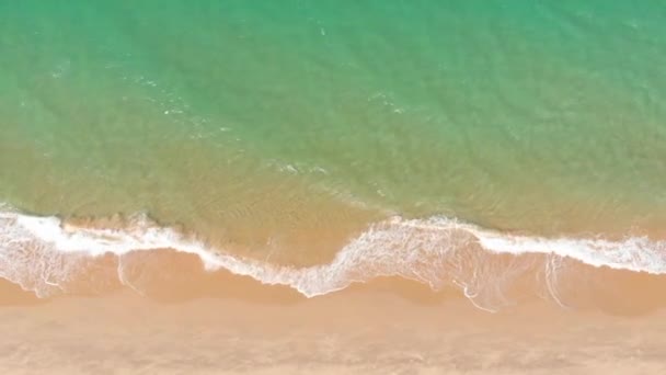 Vista aérea Vista aérea del dron desde el océano, las olas del océano, las hermosas olas no terminan los marcos uno por uno mientras las olas marinas turquesas rompen en la costa arenosa. 4K — Vídeos de Stock