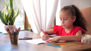 Sevimli küçük kız ya da çocuk okulu çocuğu, 7-8 yaşlarında evde rahatlama sanatçısı evde oturup resim çiziyor kağıt üzerine oturup resim çiziyor..