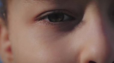 Kameraya bakan komik küçük bir kızın portresi, gözlerini kapat, güneşli bir yaz günü, anaokulunun şirin bebek yüzü, sokakta kameraya bakıyor..