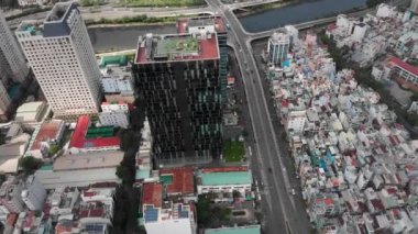 Hava araçları güzel mavi bir denizin arka planına karşı gökdelenleri ve yüksek binaları olan kuşbakışı bir şehirden güzel bir görüntü alırlar. 4K.