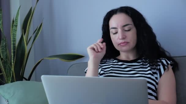 랩탑 (Laptop) 에서 일하는 여성, 집에서 소파에 앉아 일하는 여성, 일하는 여성, 집에서 온라인 작업을 공부하기 위해 개인적으로 노트북이나 스마트폰 체크 메일에 앉아 일하는 여성. — 비디오