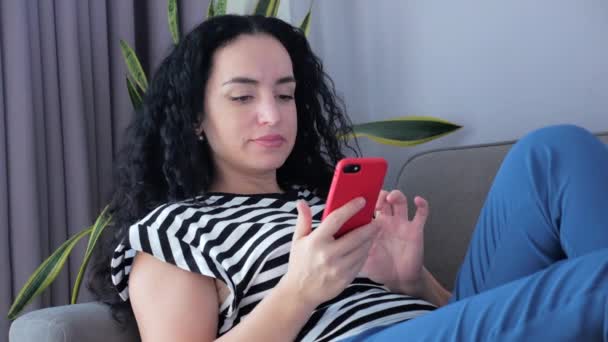 Žena psaní na telefonu sedí na pohovce doma, podnikatelka sedí doma typy na smartphone šeky mail studovat online práci doma. — Stock video