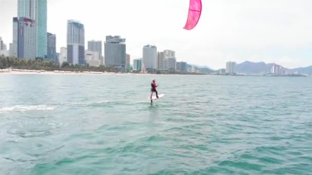 Lieu de kite surf, concept sportif, mode de vie sain, vol humain. Vue aérienne de la plage de la ville et des personnes actives pratiquant le kite surf et la planche à voile. — Video