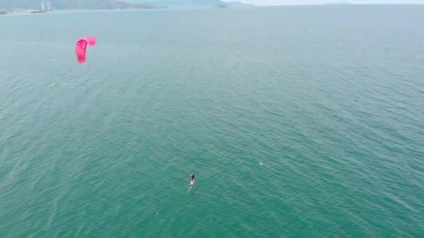 Lugar de kitesurf, concepto deportivo, estilo de vida saludable, vuelo humano. Vista aérea de la playa de la ciudad y gente activa practicando kitesurf y windsurf. — Vídeos de Stock