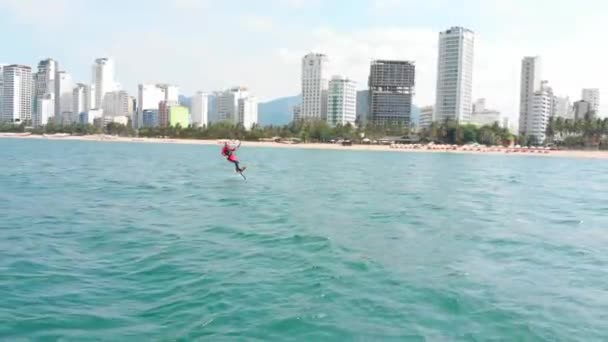 Acrobatische sprong van professionele kitesurfer op de zee golf, atleet tonen sport truc springen met vlieger en boord in de lucht. Extreme watersport en zomervakantie concept — Stockvideo