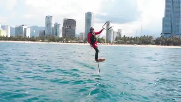 Extremer Wassersport und Sommerferienkonzept. Professioneller Kitesurfer auf der Meereswelle, Athlet zeigt Trickspringen mit Drachen und Brett in der Luft. — Stockvideo