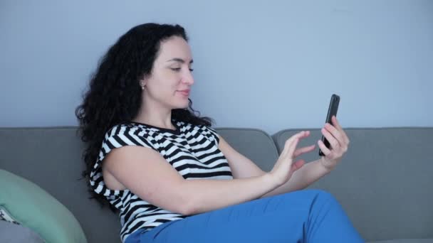 Vrouw typen op de telefoon zitten op de bank thuis, zakenvrouw zit thuis types op smartphone controles e-mail om online werk te studeren thuis. — Stockvideo