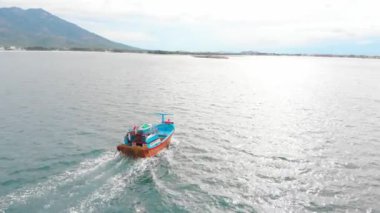 Profesyonel balıkçı teknesi, balık tuttuktan sonra sabah gün ışığında limana döner. Yüksek hızda mürekkep balığı ve ıstakoz avlamak için yengeç tuzakları olan bir balıkçı teknesinin insansız hava aracından ateş eder.
