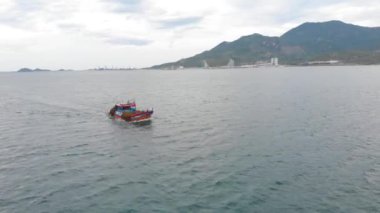 Profesyonel balıkçı teknesi, balık tuttuktan sonra sabah gün ışığında limana döner. Yüksek hızda mürekkep balığı ve ıstakoz avlamak için yengeç tuzakları olan bir balıkçı teknesinin insansız hava aracından ateş eder.