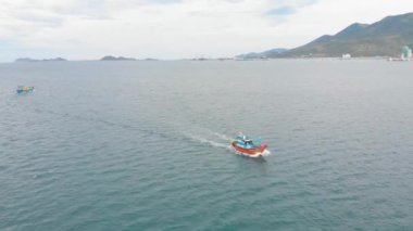 Profesyonel balıkçı teknesi, balık tuttuktan sonra sabah gün ışığında limana döner. Yüksek hızda mürekkep balığı ve ıstakoz avlamak için yengeç tuzakları olan bir balıkçı teknesinin insansız hava aracından ateş eder.