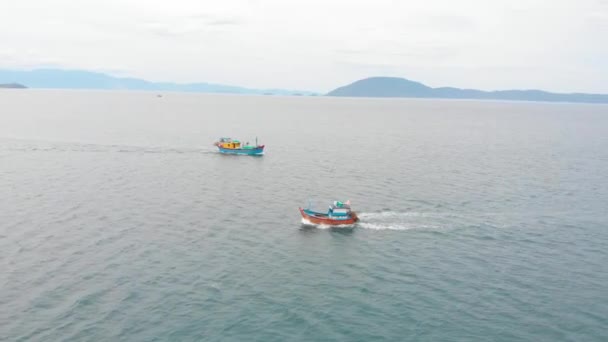 Bateau de pêche professionnel retourne au port le matin au soleil après la pêche, tir à partir d'un drone d'une goélette de pêche asiatique un bateau avec des pièges à crabe pour calmar et homard à grande vitesse — Video