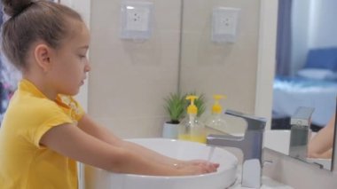 El yıkama kavramı. Küçük kız ya da çocuk ellerini sabunla yıkıyor. Virüs ve bakterilerin yayılmasını önlemek için ellerini yıkıyor. Kişisel hijyen ya da Önleme Coronavirüs Çovid 19