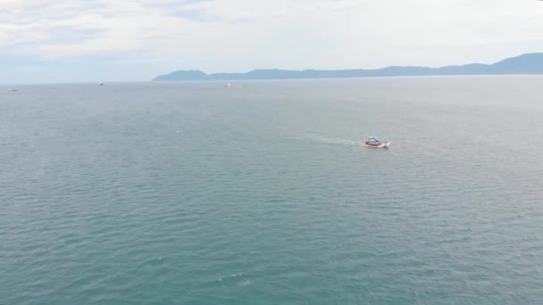 Fischerboot kehrt morgens in der Sonne nach dem Fischen in den Hafen zurück und schießt von der Drohne eines asiatischen Fischereischoners ein Boot mit Krabbenfallen für Tintenfische und Hummer bei hoher Geschwindigkeit — Stockvideo