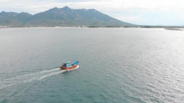 Profesyonel balıkçı teknesi, balık tuttuktan sonra sabah gün ışığında limana döner. Yüksek hızda mürekkep balığı ve ıstakoz avlamak için yengeç tuzakları olan bir balıkçı teknesinin insansız hava aracından ateş eder.