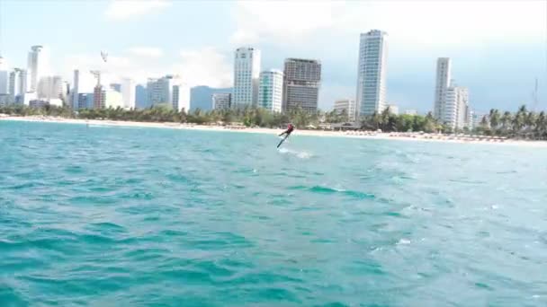 Koncepcja sportów wodnych i wakacji letnich. Profesjonalny kite surfer na fali morskiej, sportowiec pokazując trik sportowy skoki z latawcem i deską w powietrzu. — Wideo stockowe