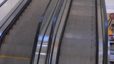 Camlar ve Metal Merdivenlerle Yürüyen Yürüyen Yürüyen Merdiven. Alışveriş merkezinde yürüyen merdiven taşınıyor. Manzara 'yı kapatın. İnsanlar Maske Covid-19.