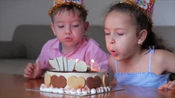 Koncepcja szczęśliwej rodziny. Szczęśliwy, czteroletni chłopiec świętuje urodziny z rodziną, jego młodsza siostra pomogła mu zdmuchnąć świeczki.. — Wideo stockowe